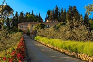 a road in front of a house with flowers at Le Filigare Winery & Accomodation in Chianti in San Donato in Poggio