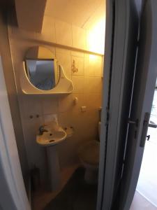 a bathroom with a sink and a toilet and a mirror at Pokoje przy Parku in Gdańsk