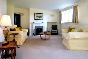 a living room with two couches and a fireplace at Garbity Cottage in Fochabers