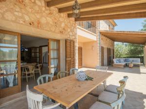 a wooden table and chairs on a patio at Luxury finca Ses Quaranta in Campos