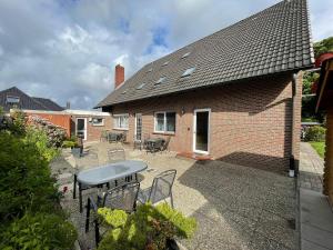 a patio with chairs and a table and a house at Ferienwohnung Currle in Wangerland