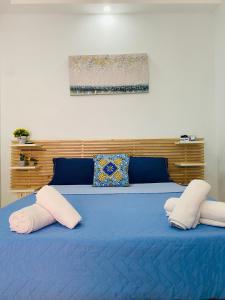 - un lit bleu avec 2 oreillers au-dessus dans l'établissement Casa Nanà, à Pouzzoles