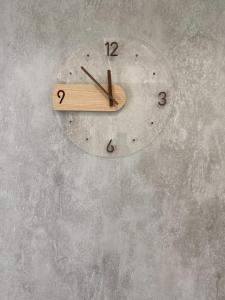 a wooden clock hanging on a wall at Kozy Stay in Taitung City
