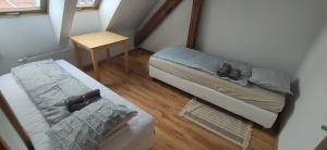Habitación pequeña con 2 camas y mesa. en Apartament Gliwice Centrum en Gliwice