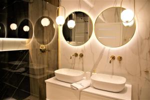 Un baño con un lavabo y dos espejos en la pared. en Apartament Grand Royal Maris Ustka - najlepsza lokalizacja, bardzo blisko portu i plaży, parking, nowy kameralny apartamentowiec, ścisłe centrum, en Ustka 52 fotos más