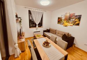 una sala de estar con una mesa y un sofá en Apartmani Vojinović, en Zlatibor