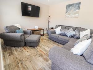 ein Wohnzimmer mit 2 Sofas und einem TV in der Unterkunft Sea Breeze Cottage in Prestatyn