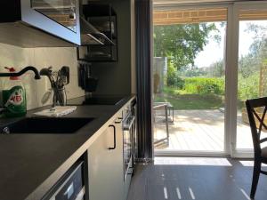 a kitchen with a sink and a door to a patio at TinyHouze in Karlskrona
