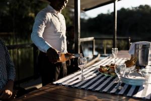 a man pouring wine into glasses on a table at Tzaneen Country Lodge in Tzaneen