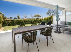a patio with a wooden table and chairs at Emerald Green 2380 Golf & beach in San Roque