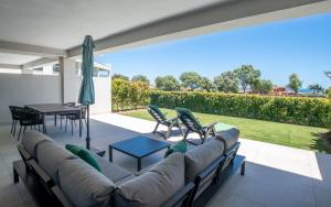 kanapę na patio ze stołem i krzesłami w obiekcie Emerald Green 2380 Golf & beach w mieście San Roque