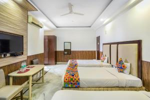 a hotel room with two beds and a flat screen tv at FabHotel Jindal Palace in New Delhi