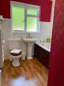 a bathroom with a toilet and a sink and a tub at The Lagg in Lagg
