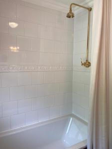 a white bathroom with a tub and a shower curtain at The Lagg in Lagg