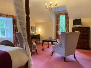 a bedroom with a bed and two chairs and a table at The Lagg in Lagg