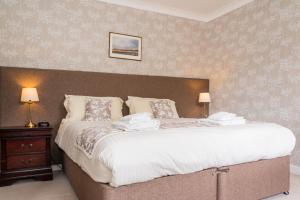 a bedroom with a large bed with two lamps at The Lagg in Lagg