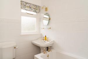 a white bathroom with a sink and a toilet at The Lagg in Lagg
