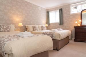 a bedroom with two beds and a mirror at The Lagg in Lagg