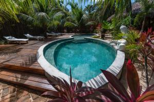 uma piscina num quintal com palmeiras em Pousada Villa Zen em Barra Grande