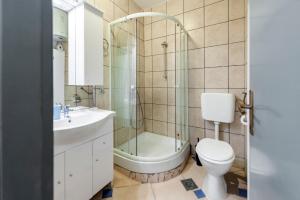 een badkamer met een douche, een toilet en een wastafel bij Guesthouse Valsaresi in Rovinj