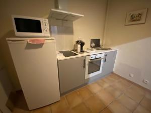 uma cozinha com um micro-ondas em cima de um frigorífico em Maison le Rêve em Falicon