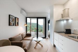 a kitchen and living room with a couch and a table at Cabañas Alcobas do Sil Ecoturismo in Parada del Sil