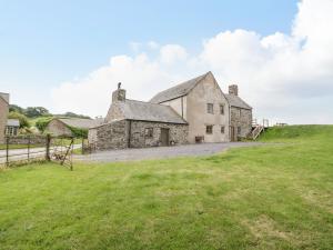 an old stone house on a hill with a green field at Yr Hen Dy in Colwyn Bay