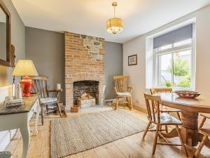 a living room with a fireplace and a table and chairs at 7 Severn Terrace in Watchet