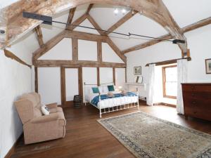 a bedroom with a bed and a chair in a room at Yr Hen Dy in Colwyn Bay