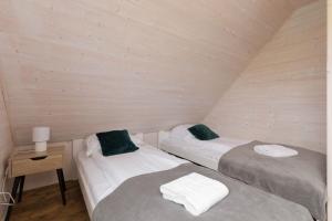 2 aparte bedden in een kamer met een houten muur bij Strzeżenice House by Renters in Strzezenice