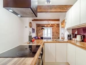 una cucina con armadi bianchi e piano di lavoro nero di Up-Top Cottage a Holmfirth