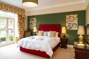 a bedroom with a large bed with green walls at The Lagg in Lagg