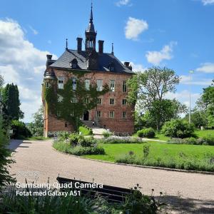 um velho edifício de tijolos com uma torre em cima dele em Naturnära enkel rum B&B i Uppsala Ramstalund em Uppsala
