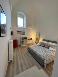 a large bedroom with a bed and a window at Palazzo Zagarella HOWME in Matera