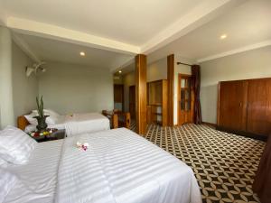 - une chambre d'hôtel avec 2 lits fleuris dans l'établissement Villa Secret Garden Kep-Panoramic view-WI-FI, à Phumĭ Prey Srâmaôch