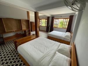 a bedroom with two beds and two windows at Villa Secret Garden Kep-Panoramic view-WI-FI in Phumĭ Prey Srâmaôch