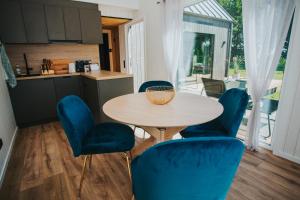 een keuken met een houten tafel en blauwe stoelen bij Goba Sauleskempings in Mērsrags