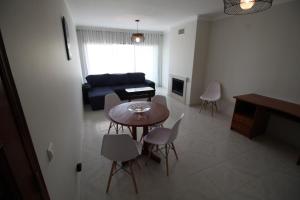 - un salon avec une table, des chaises et un canapé dans l'établissement Urban Beach - Apartamento Pôr do Sol, à Portimão