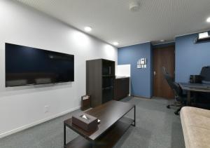 an office with a couch and a table and a tv at Villa Front Kyoto Seimei in Kyoto