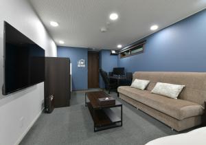 a living room with a couch and a table at Villa Front Kyoto Seimei in Kyoto