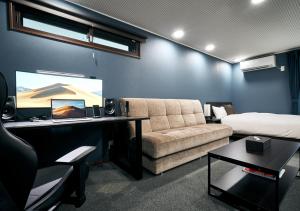 een kamer met een bank, een bed en een bureau bij Villa Front Kyoto Seimei in Kyoto