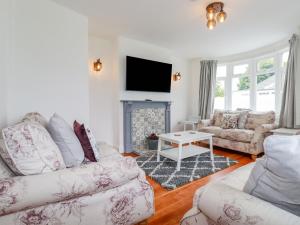 a living room with two couches and a fireplace at Pen-Y-Thon House in Newquay