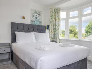 a bedroom with a large white bed with a window at Pen-Y-Thon House in Newquay