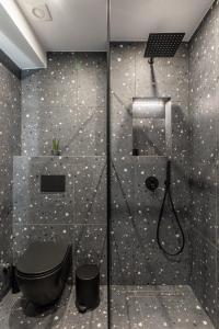 a bathroom with a shower with a black toilet at Ermoo Athens Modern Living in Athens +50 photos