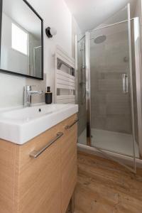uma casa de banho com um lavatório e um chuveiro em NOUVEAU - T2 Industriel - Quartier historique - WiFi - Parking - Netflix em Hennebont