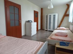 a bedroom with two beds and a wooden floor at Dom Gościnny Przy Jeziorze in Gardna Wielka
