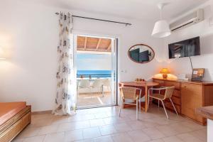 a living room with a dining table and a view of the ocean at Glyfada Home 113 by New Era in Menigos Resort Apartments in Glyfada +29 photos