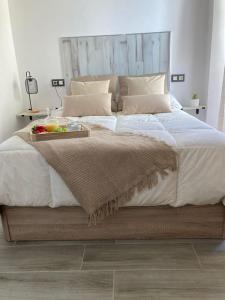 a bedroom with a large bed with a tray on it at Coqueto Apartamento de Playa con Piscina y Terraza in Valencia