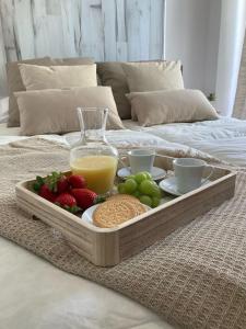 bandeja de frutas y verduras en la cama en Coqueto apartamento de Playa con Piscina y Terraza, en Valencia