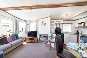 a living room with a couch and a table at Dog Friendly Lovely Caravan by Beach Prestatyn N Wales 6 Berth Read full Host details before booking Mon in to Fri out Fri in to Mon out Mon to Mon Fri to Fri ONLY in Prestatyn